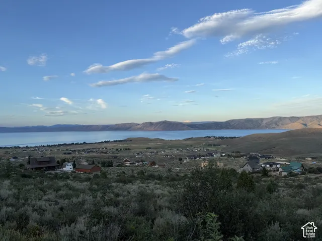 Expansive landscape featuring an elevated perspective of the surrounding lake, rolling mountain ranges, and native high-desert vegetation