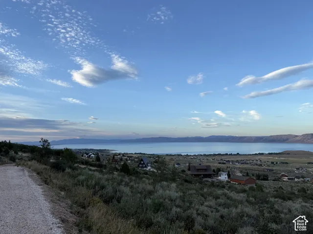 Elevated lot featuring native brush landscape, gravel path access, and expansive water and mountain scenery