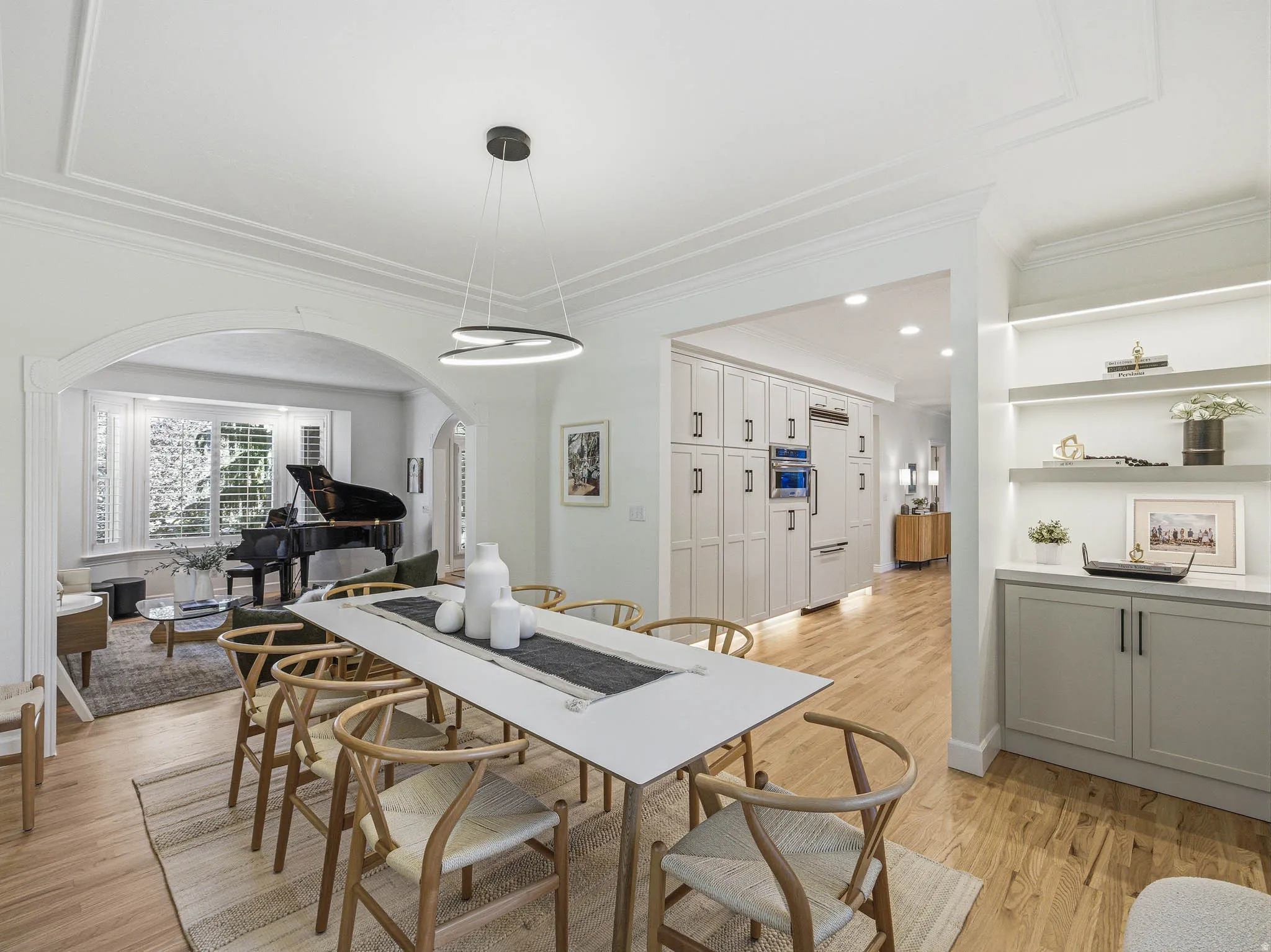 Dining area featuring a modern chandelier, wood-finish flooring, and crown molding