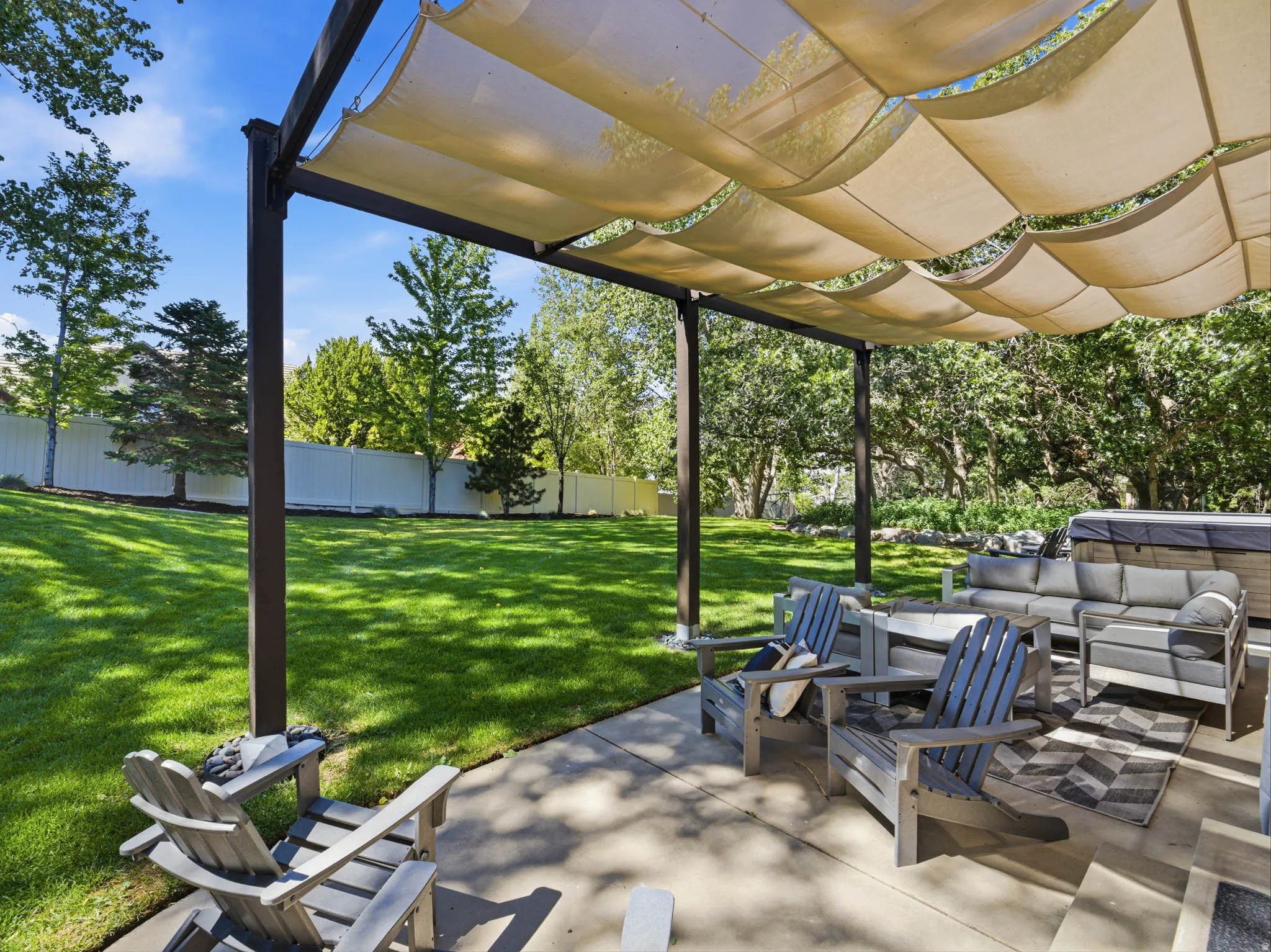 Expansive outdoor patio featuring a pergola with a retractable shade canopy