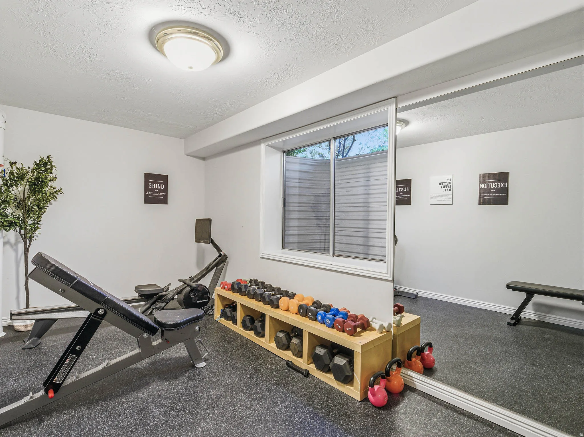 Dedicated exercise room featuring resilient rubber flooring and a large wall-mounted mirror