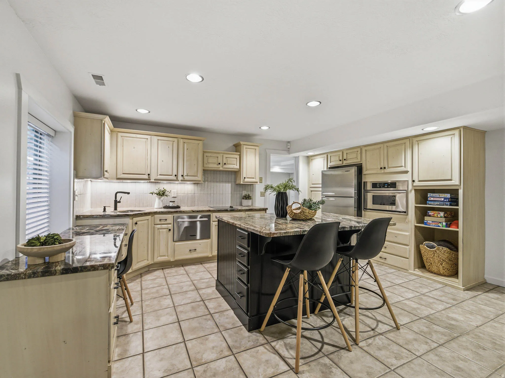 Spacious kitchen featuring an expansive center island, light-toned cabinetry, and tile flooring
