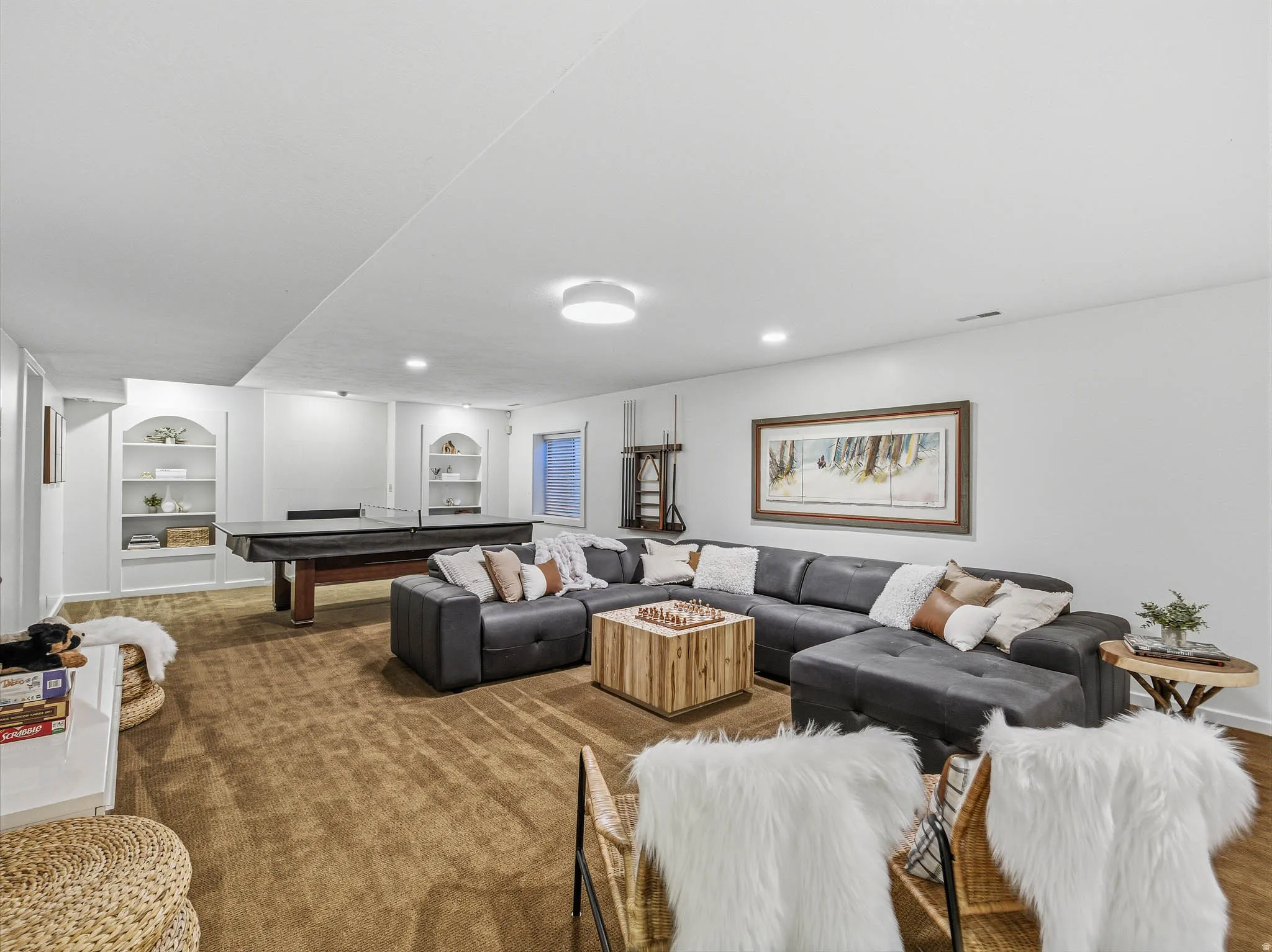 Spacious lower-level entertainment area featuring recessed lighting and plush brown carpeting