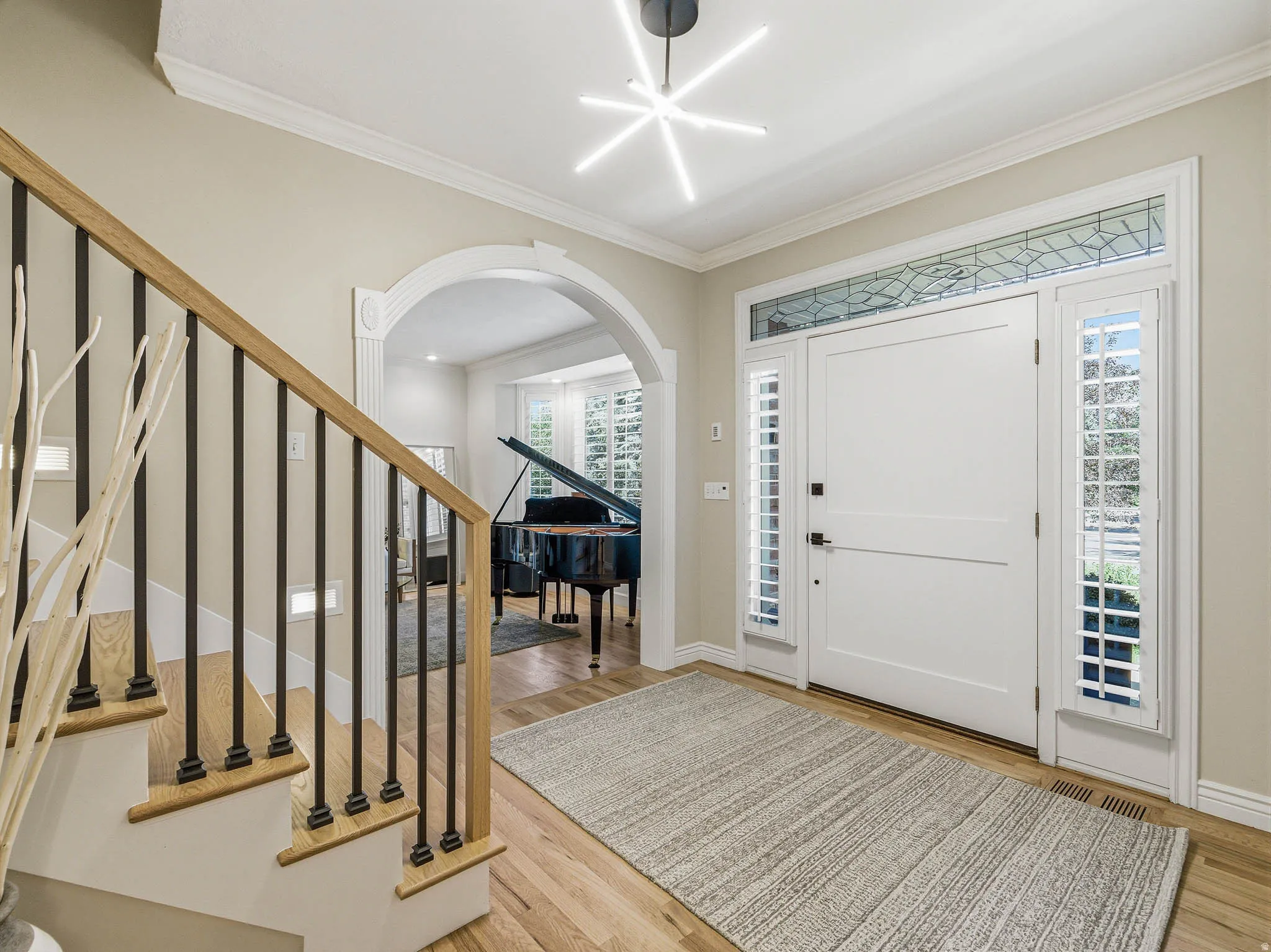 Entryway featuring wood-finish flooring and a contemporary linear chandelier