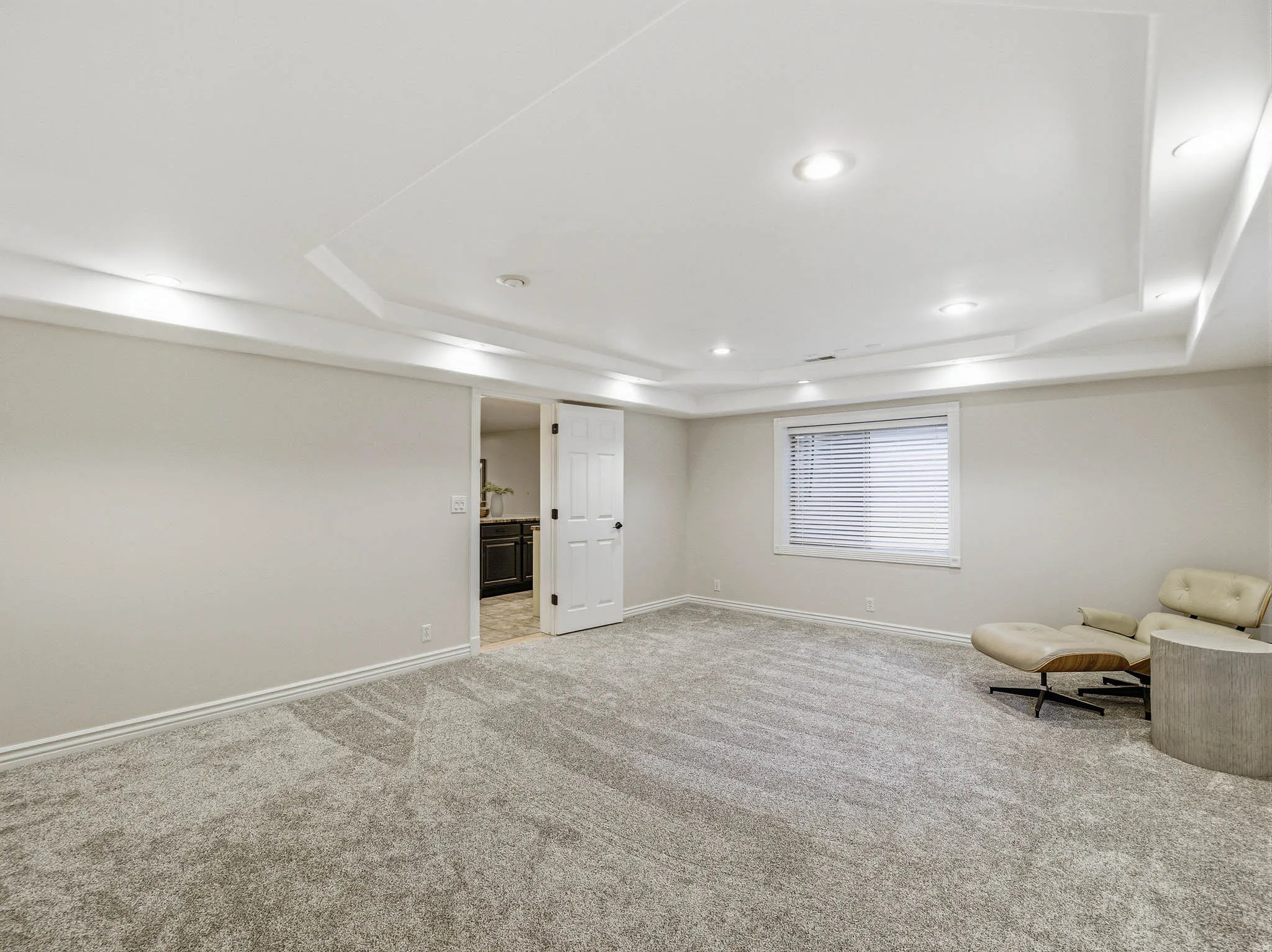 Spacious room with gray carpet flooring and neutral wall tones