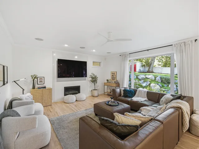 Living area featuring wood-finish flooring, a contemporary ceiling fan, recessed lighting, and a built-in fireplace