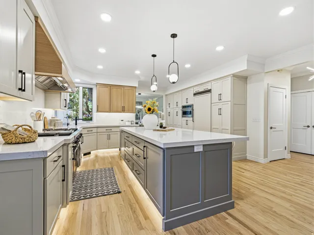 Central kitchen island with gray paneled cabinetry and a white countertop