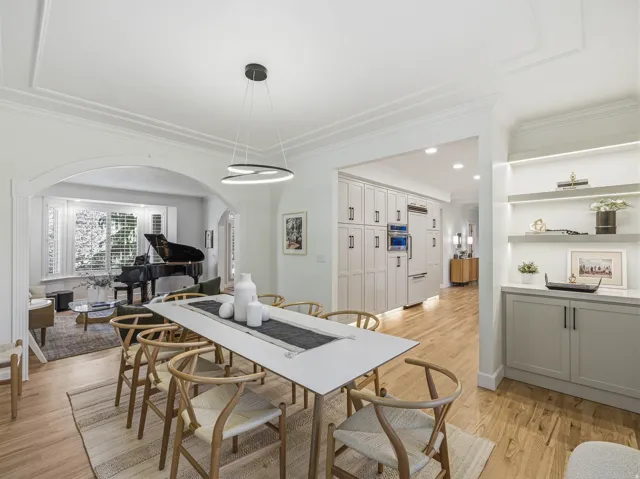 Dining area featuring a modern chandelier, wood-finish flooring, and crown molding