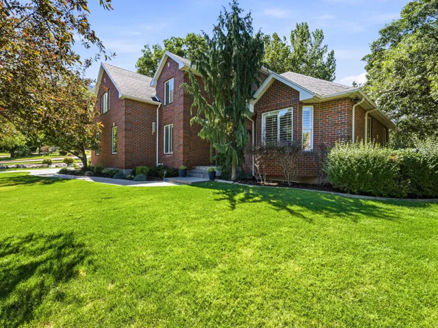 Manicured front lawn with mature trees and shrubbery