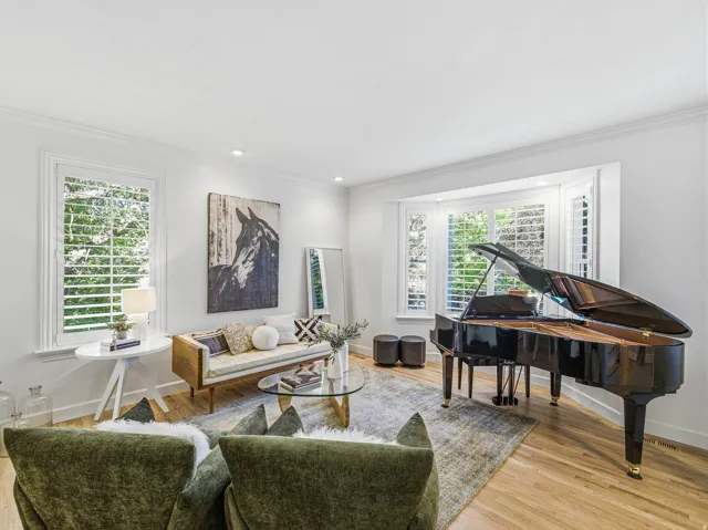 Living area featuring a grand piano and hardwood flooring