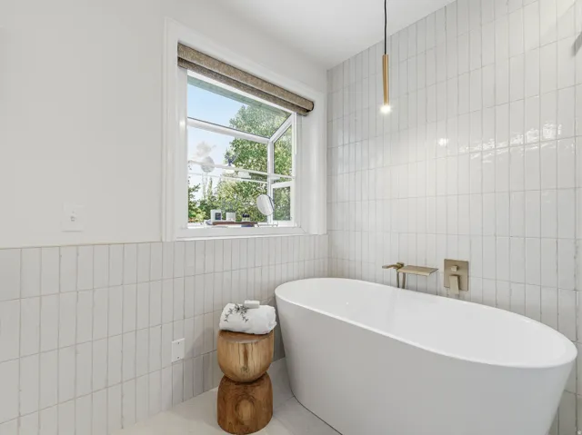 Freestanding soaking tub with brushed brass fixtures