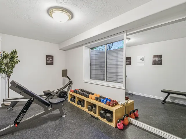 Dedicated exercise room featuring resilient rubber flooring and a large wall-mounted mirror