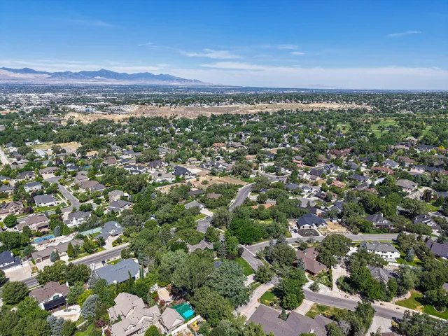 Expansive residential area featuring established homes, mature trees, and mountainous scenery