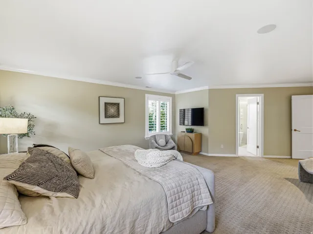 Spacious room featuring neutral carpeting, a ceiling fan, crown molding, and recessed lighting