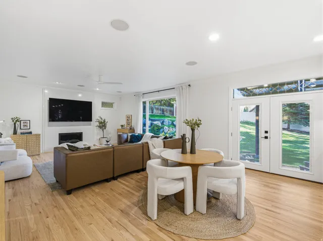 Open-concept living space with wood-finish flooring, recessed lighting, and built-in ceiling speakers