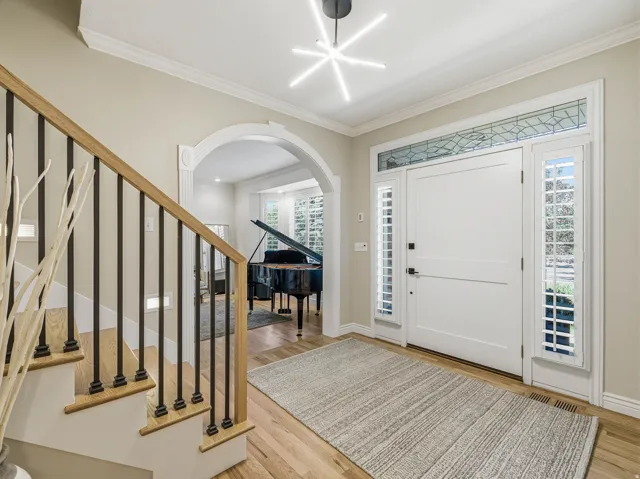Entryway featuring wood-finish flooring and a contemporary linear chandelier