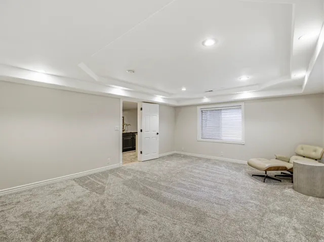Spacious room with gray carpet flooring and neutral wall tones
