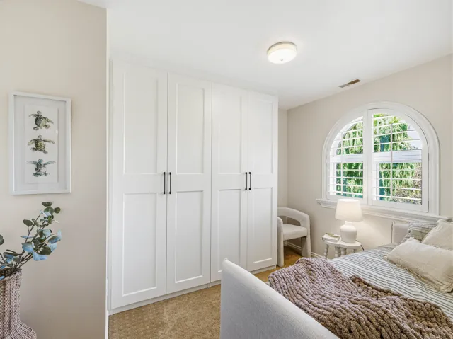 Built-in closet system with shaker-style doors and dark hardware