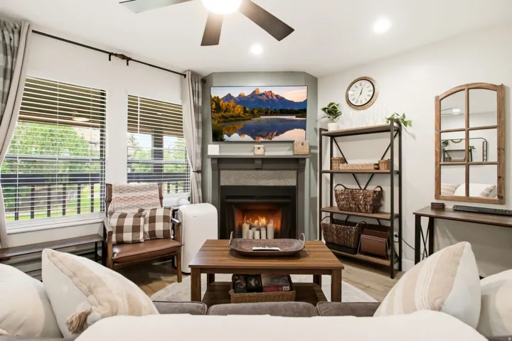 Living area featuring wood-finish flooring and a ceiling fan with integrated lighting