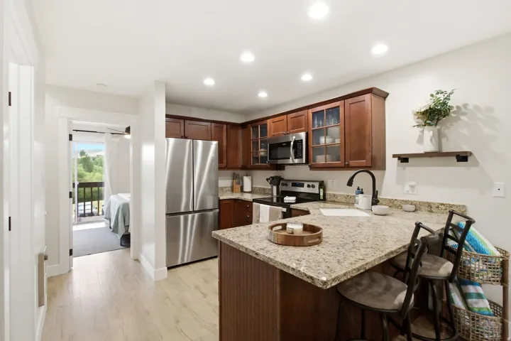 Kitchen featuring wood-finish flooring, recessed lighting, and a breakfast bar with stone countertops
