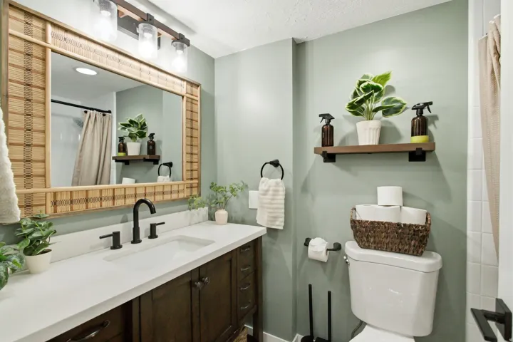 Vanity featuring a white countertop with an integrated sink, dark wood-finish cabinetry, and a matte black faucet