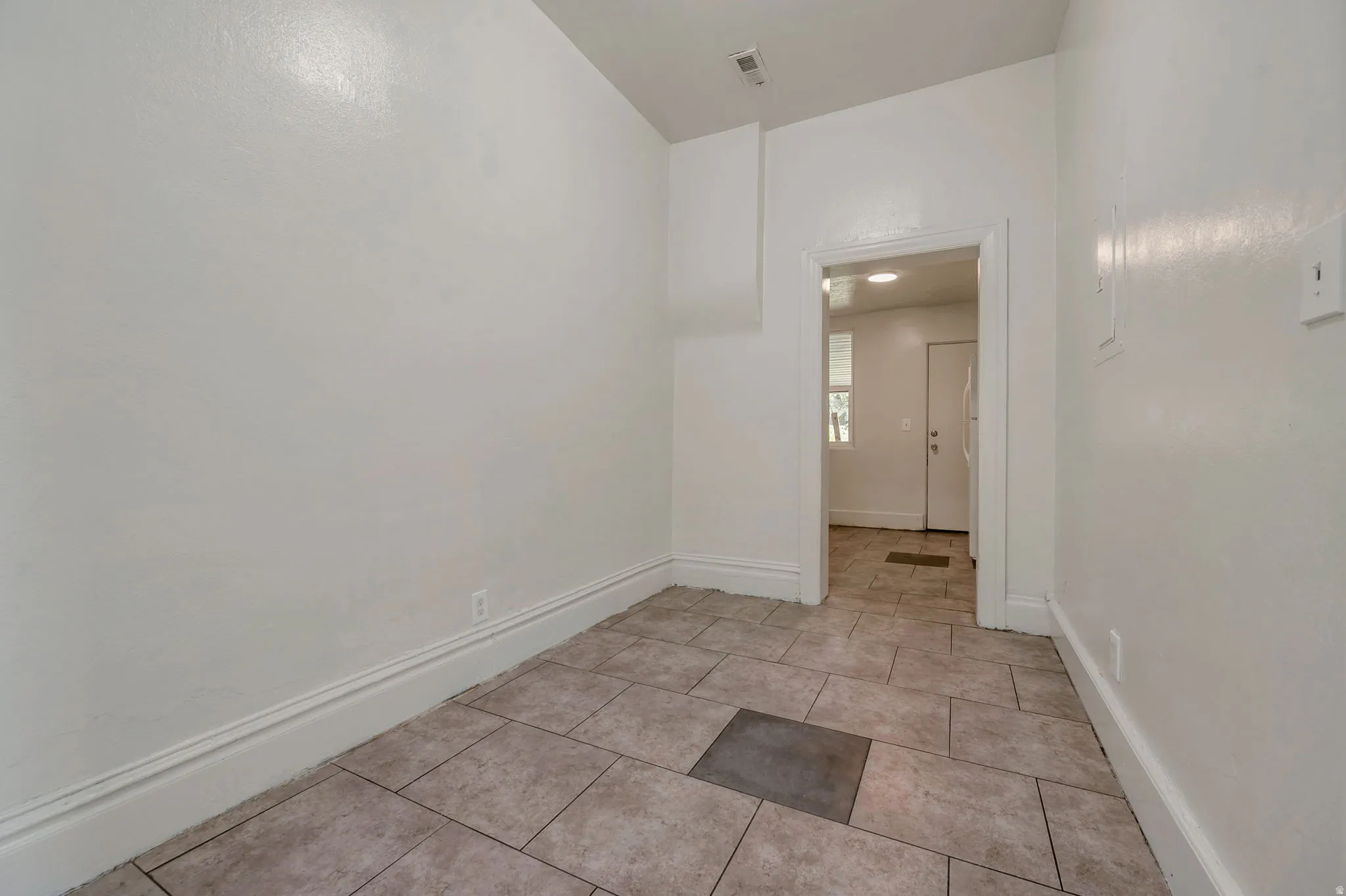 Neutral-toned rectangular tile flooring with a contrasting square insert