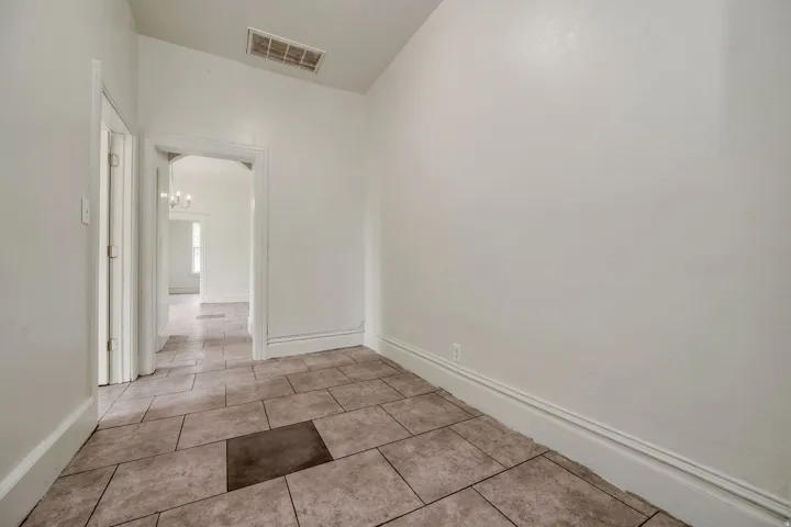 Interior space featuring light-toned tile flooring, white painted walls, and white trim