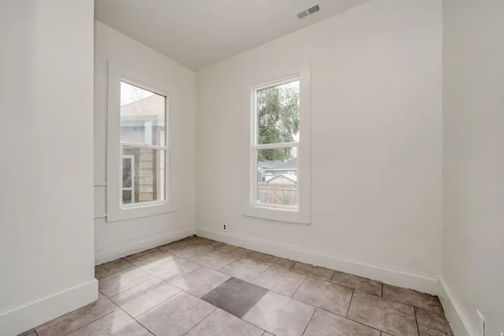 Bright room with two double-hung windows, featuring white trim and baseboards