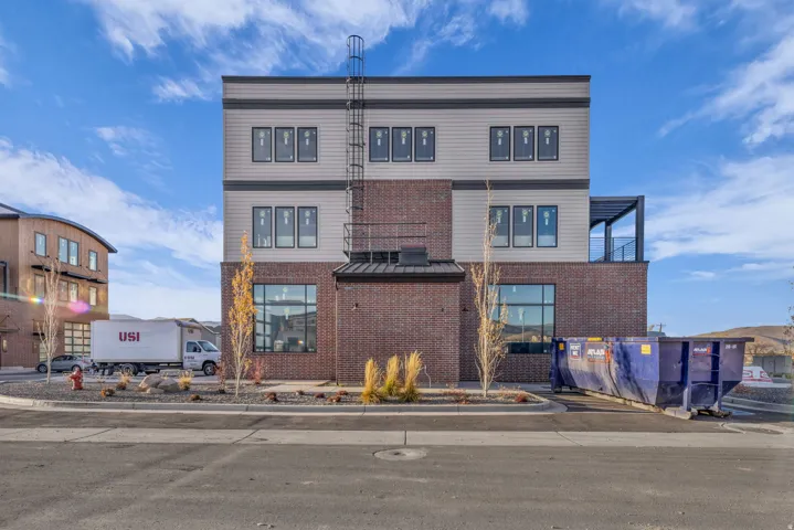 Contemporary multi-story building featuring a brick base and panel siding