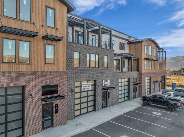Modern multi-story building featuring brick, wood-panel, and siding exteriors