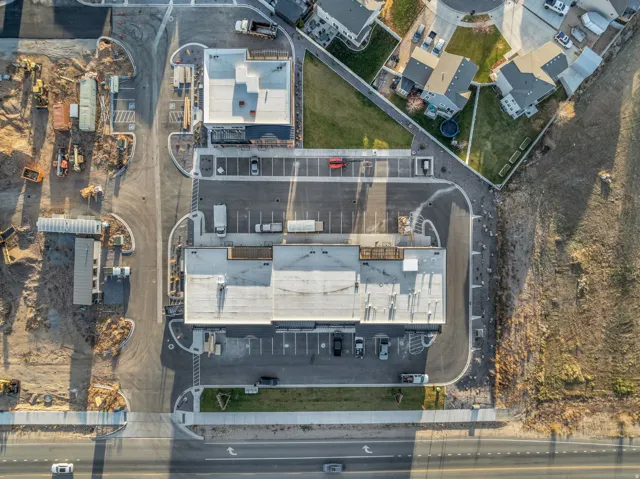 Commercial structures featuring expansive parking areas and direct road access