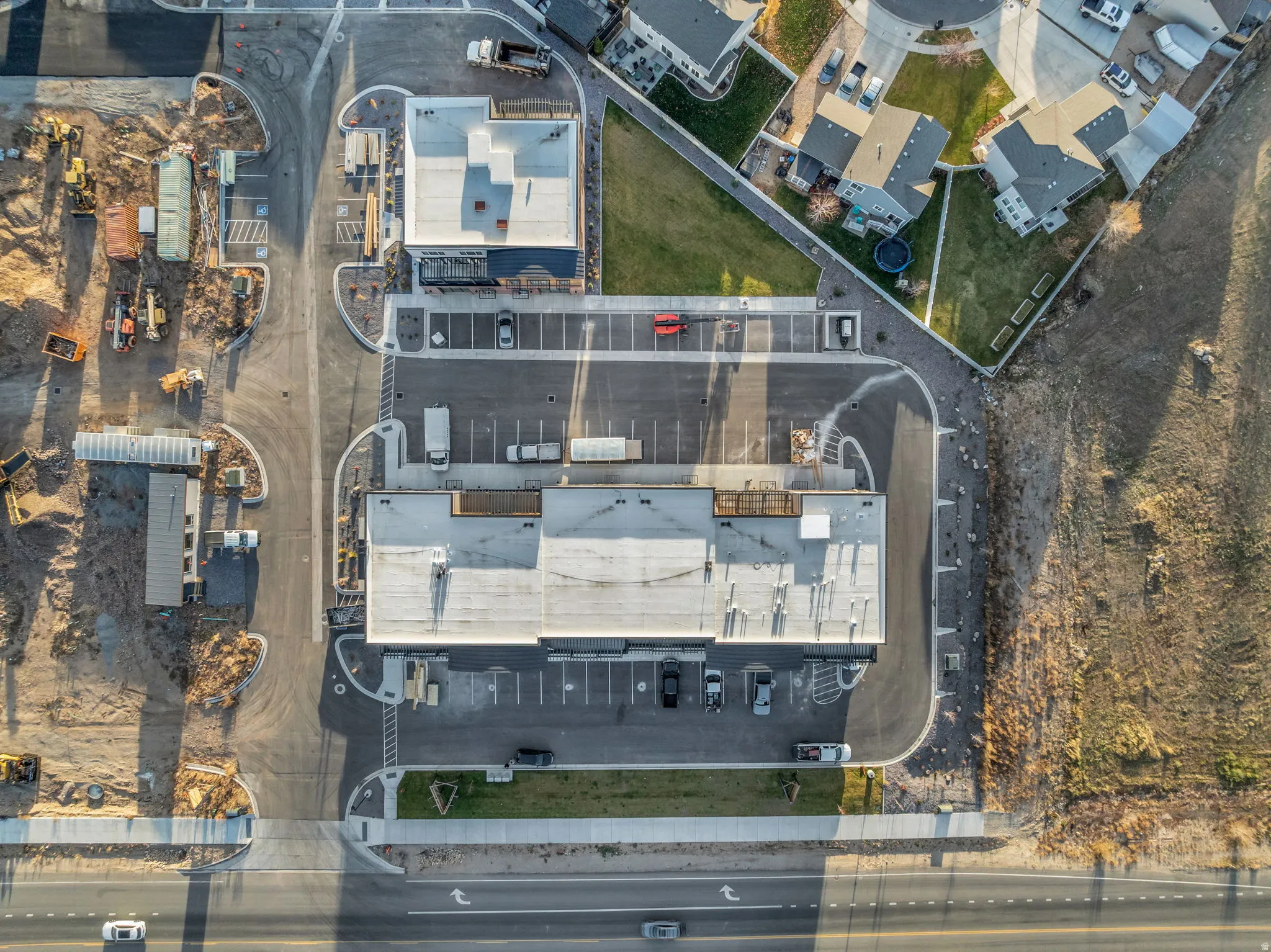 Commercial structures featuring expansive parking areas and direct road access