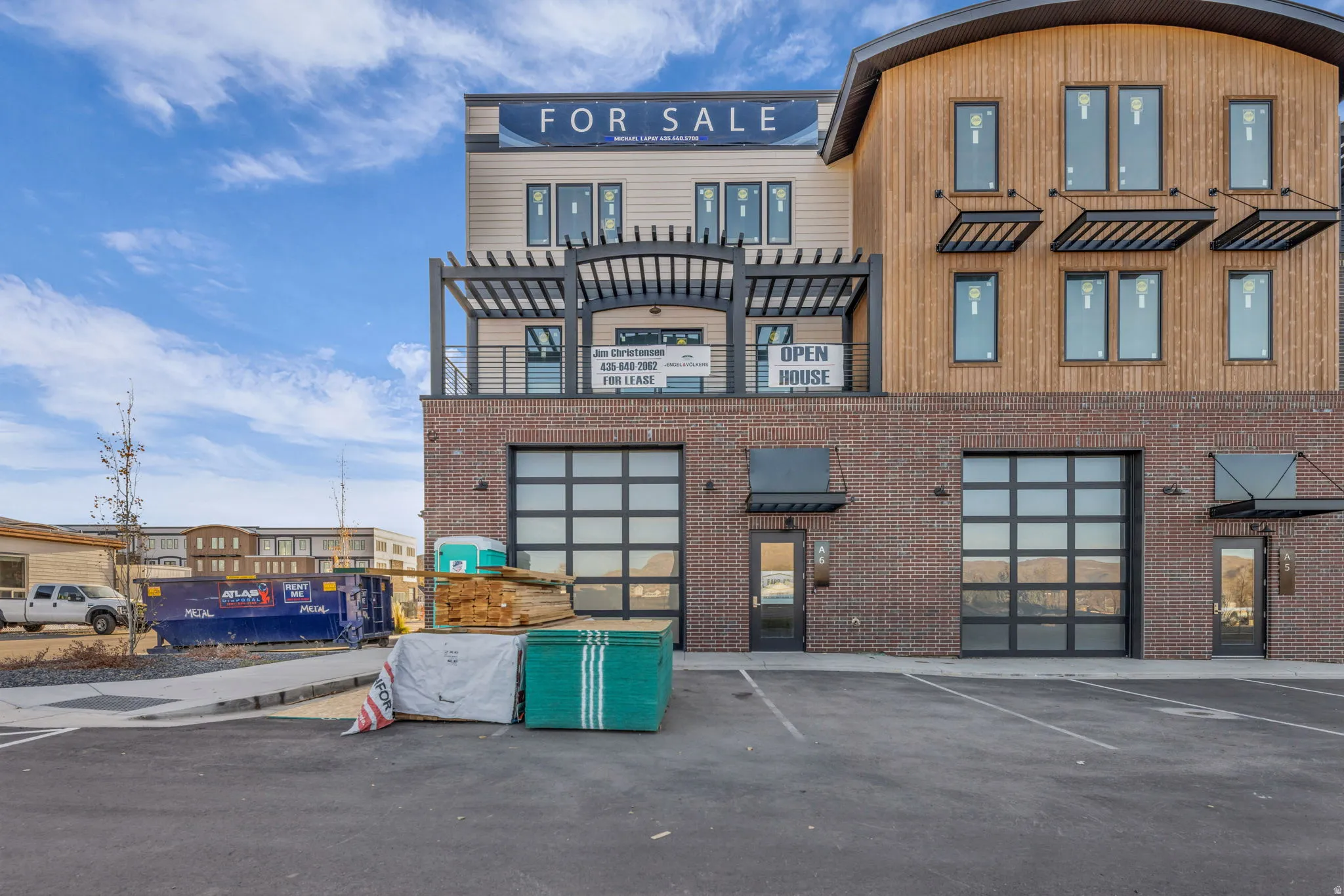 Contemporary commercial building featuring brick and vertical wood-finish siding with multiple large windows