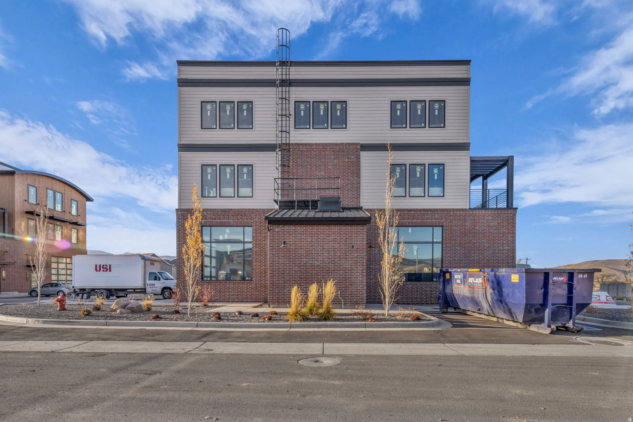 Contemporary multi-story building featuring a brick base and panel siding