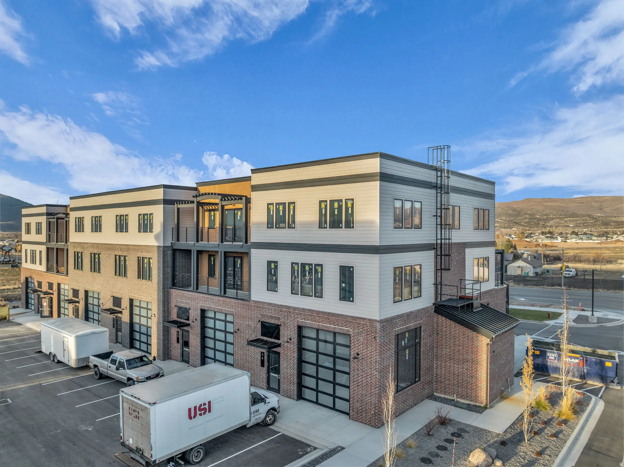Modern multi-story building featuring brick and horizontal siding facades