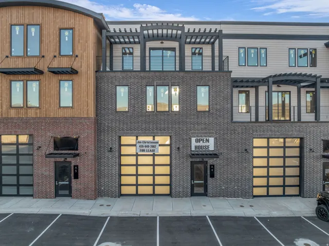 Modern multi-story building featuring varied facade materials including wood paneling and brickwork