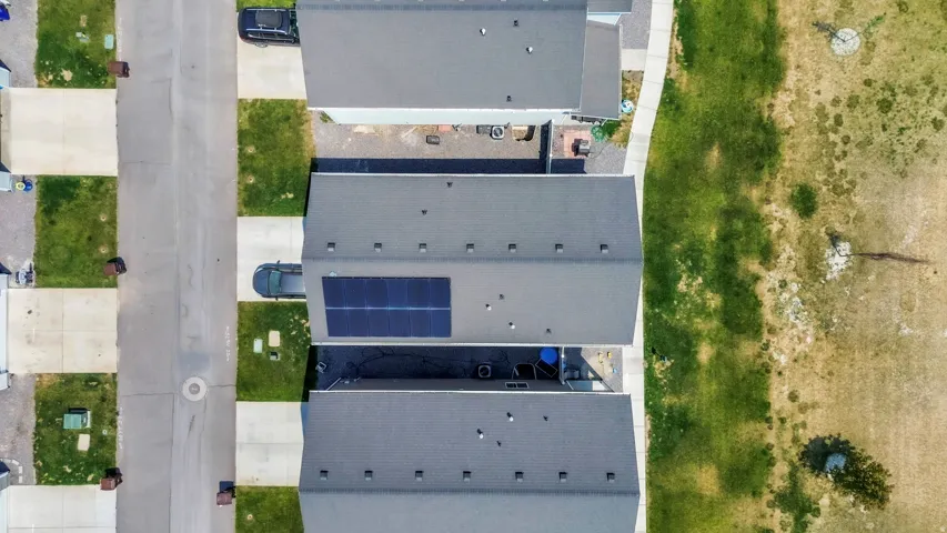 Aerial perspective showcasing a residential street with three properties featuring dark gray shingle roofs