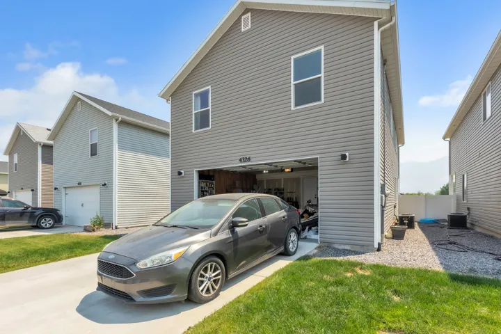 Two-story residential structure featuring gray siding and a two-car garage