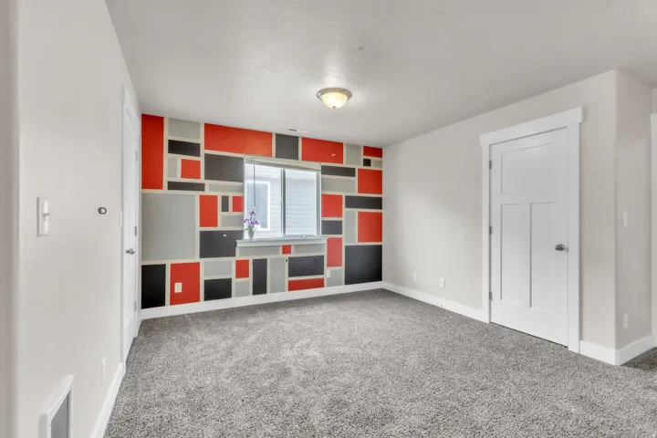 Upstairs living room with accent wall featuring a geometric pattern in red, black, and gray