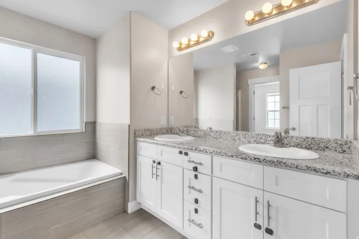 Double vanity with granite countertops and undermount sinks in the primary bathroom