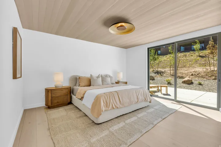 Bedroom featuring light wood-finish flooring and a complementary wood-paneled ceiling