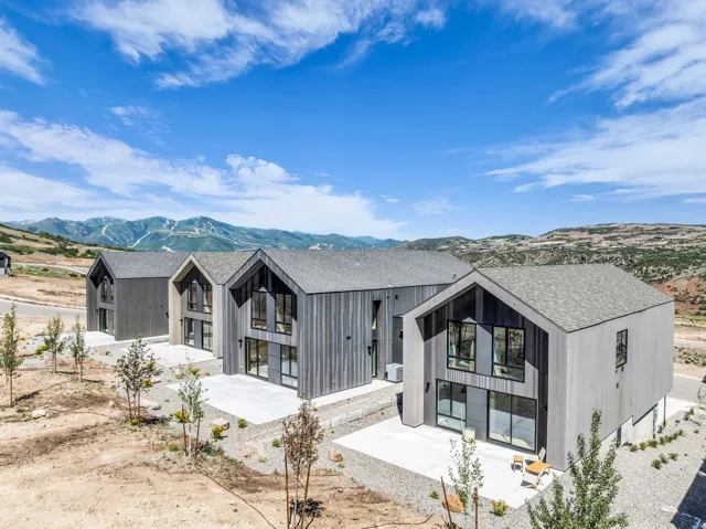 Modern architecture featuring a gabled roofline and a light-toned wood-finish exterior