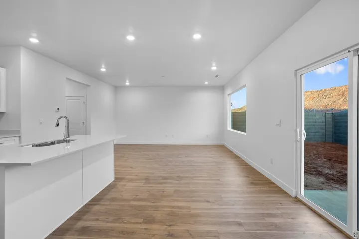 Open-concept living area featuring wood-finish flooring, recessed lighting, and a sliding glass door to the exterior