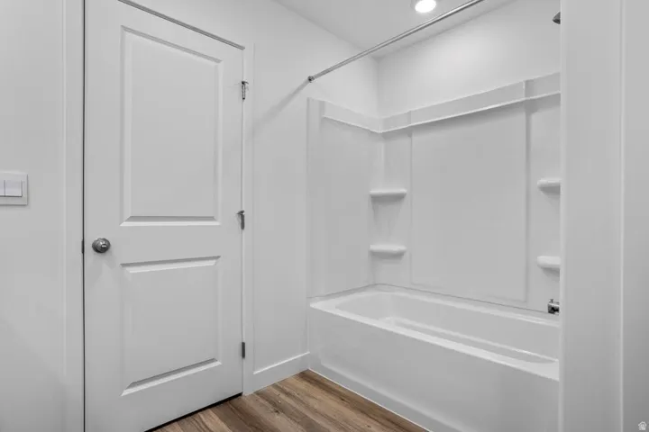 Tub/shower combination featuring integrated shelving and a chrome showerhead