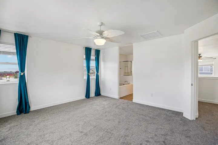 Spacious room featuring neutral carpeting and white walls