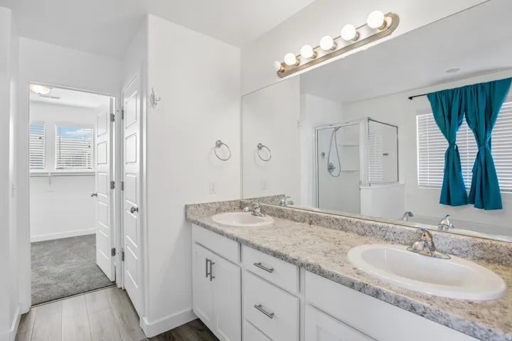 Bathroom featuring a double vanity with light-toned countertops and undermount sinks