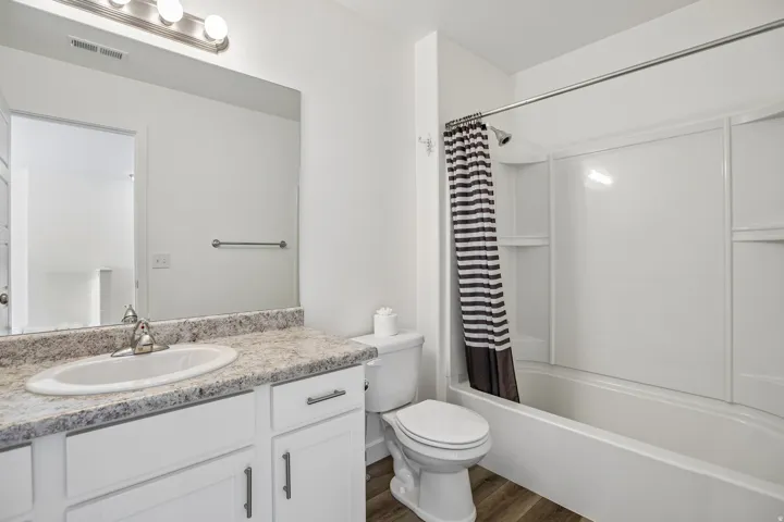 Bathroom featuring a white vanity with a patterned countertop, integral sink, and brushed nickel faucet