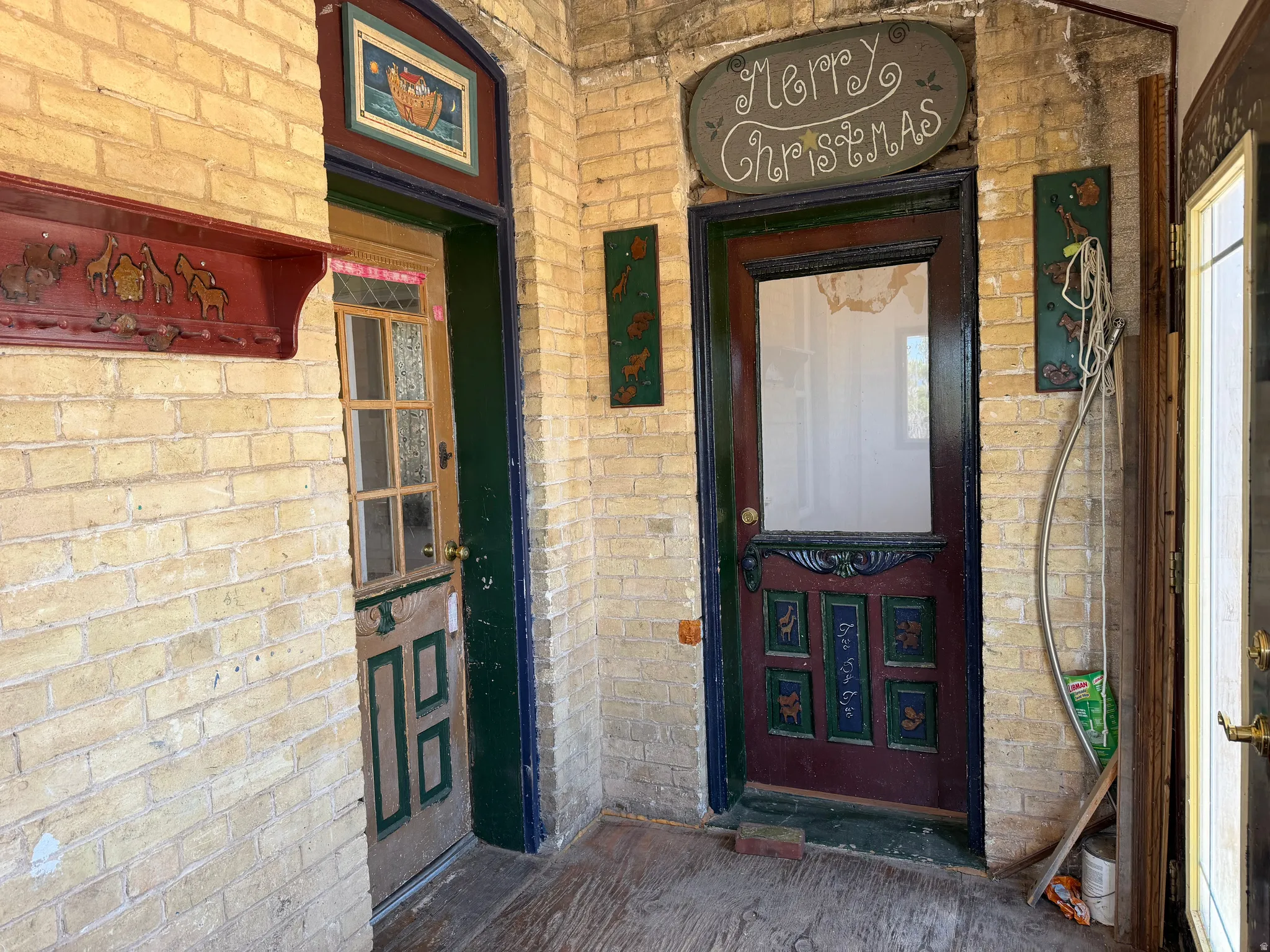 Brick-clad entryway featuring multiple doors and a wood-finish floor