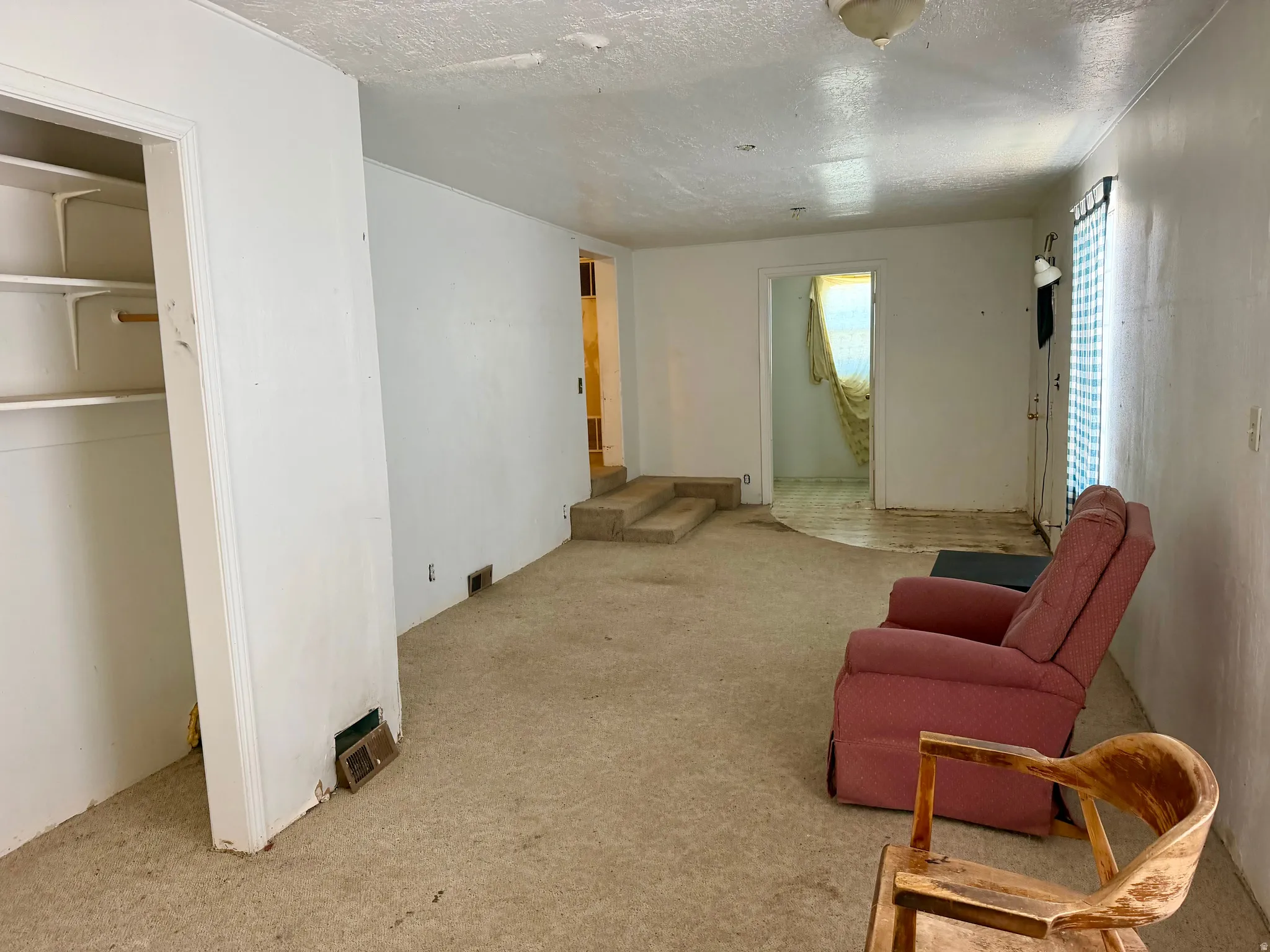 Spacious interior with neutral wall finishes and a built-in closet featuring shelving
