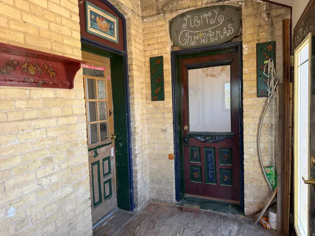 Brick-clad entryway featuring multiple doors and a wood-finish floor
